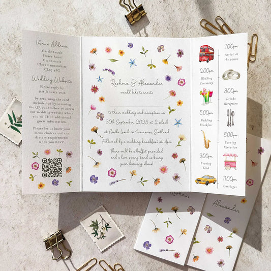 Floral wedding invitation with QR code on a textured surface