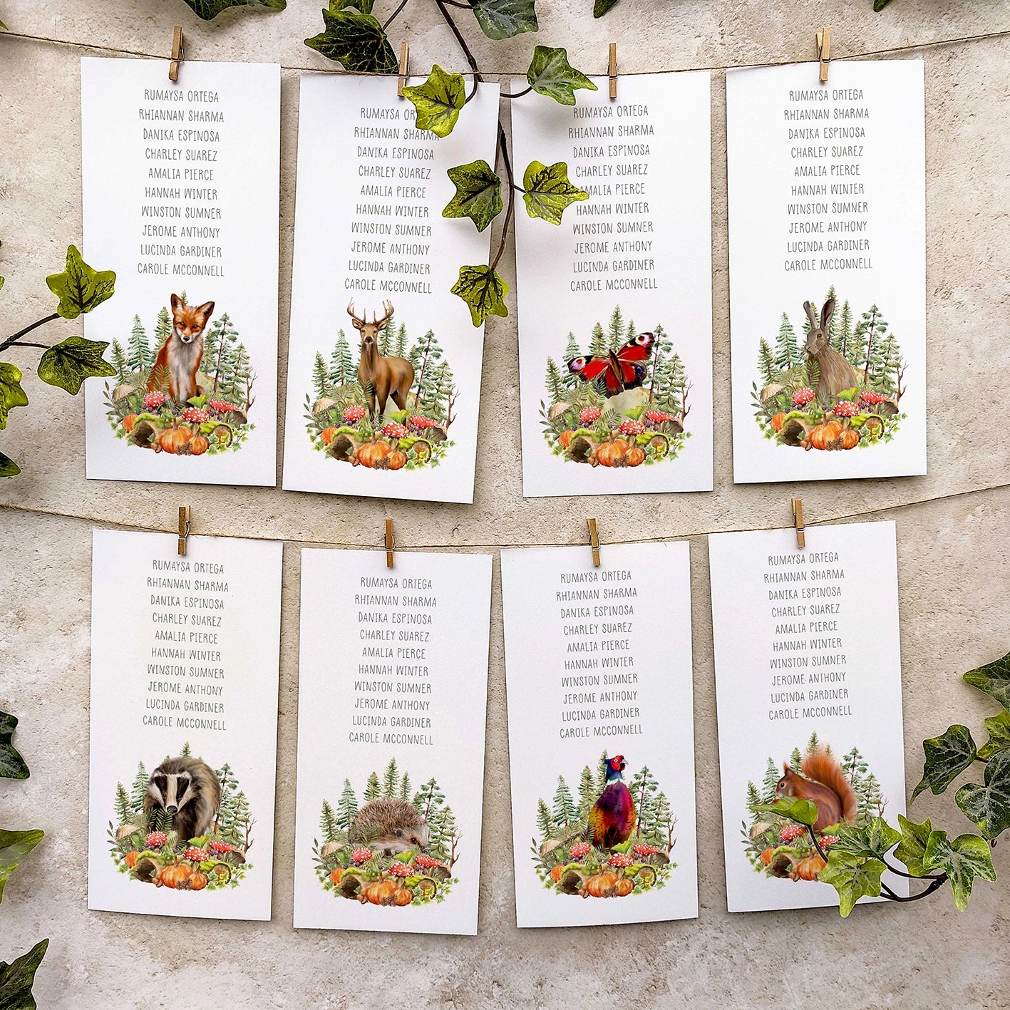 Set of table plan cards with autumn forest animals and plants on a textured surface.