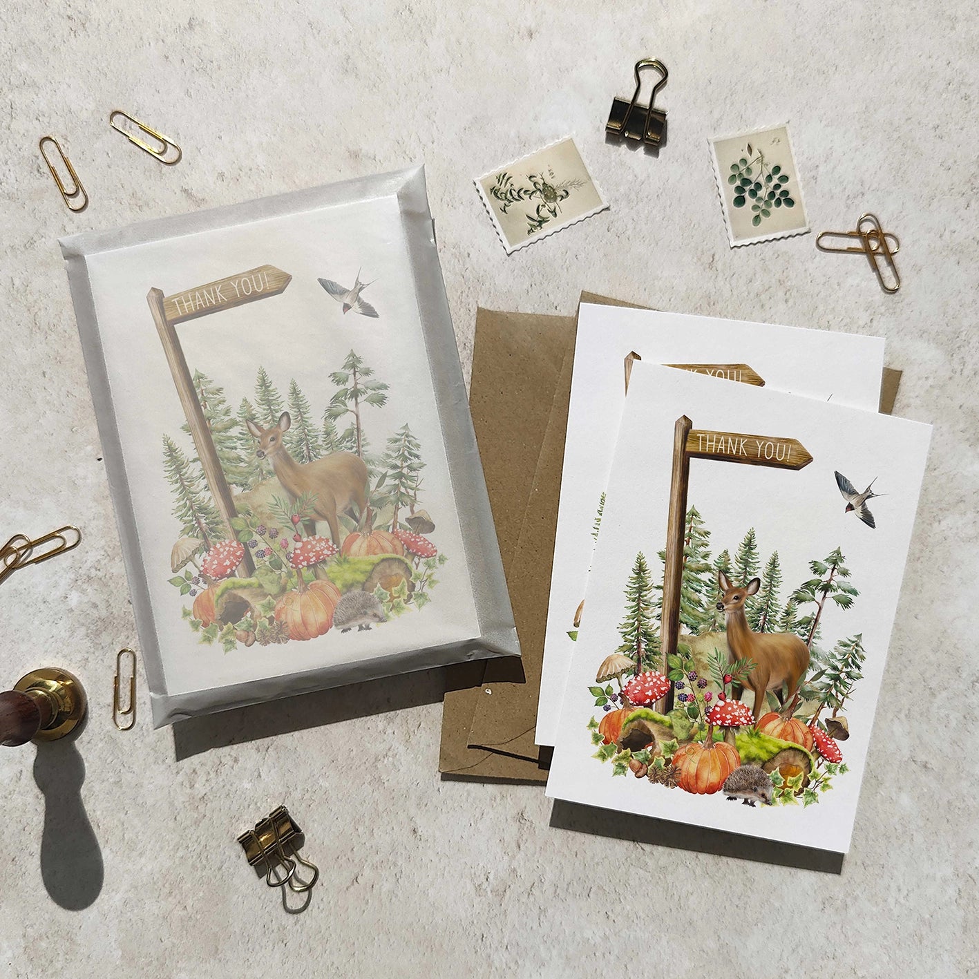 Set of greeting cards with autumn woodland nature-themed designs on a textured surface.