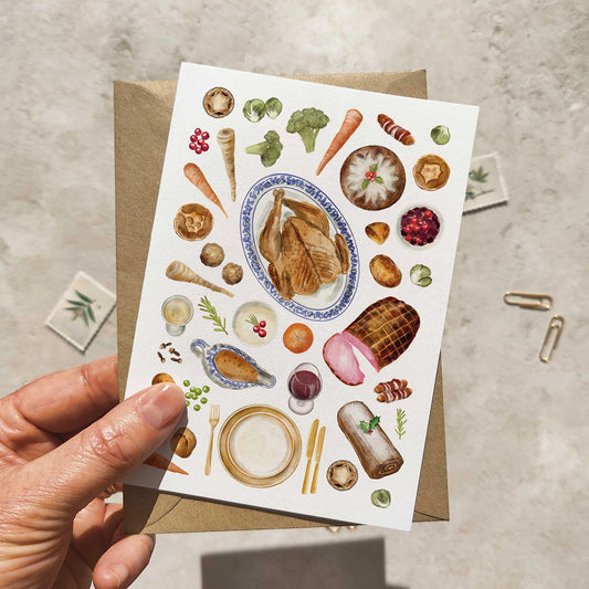 Greeting card with food illustrations held by a hand on a textured surface