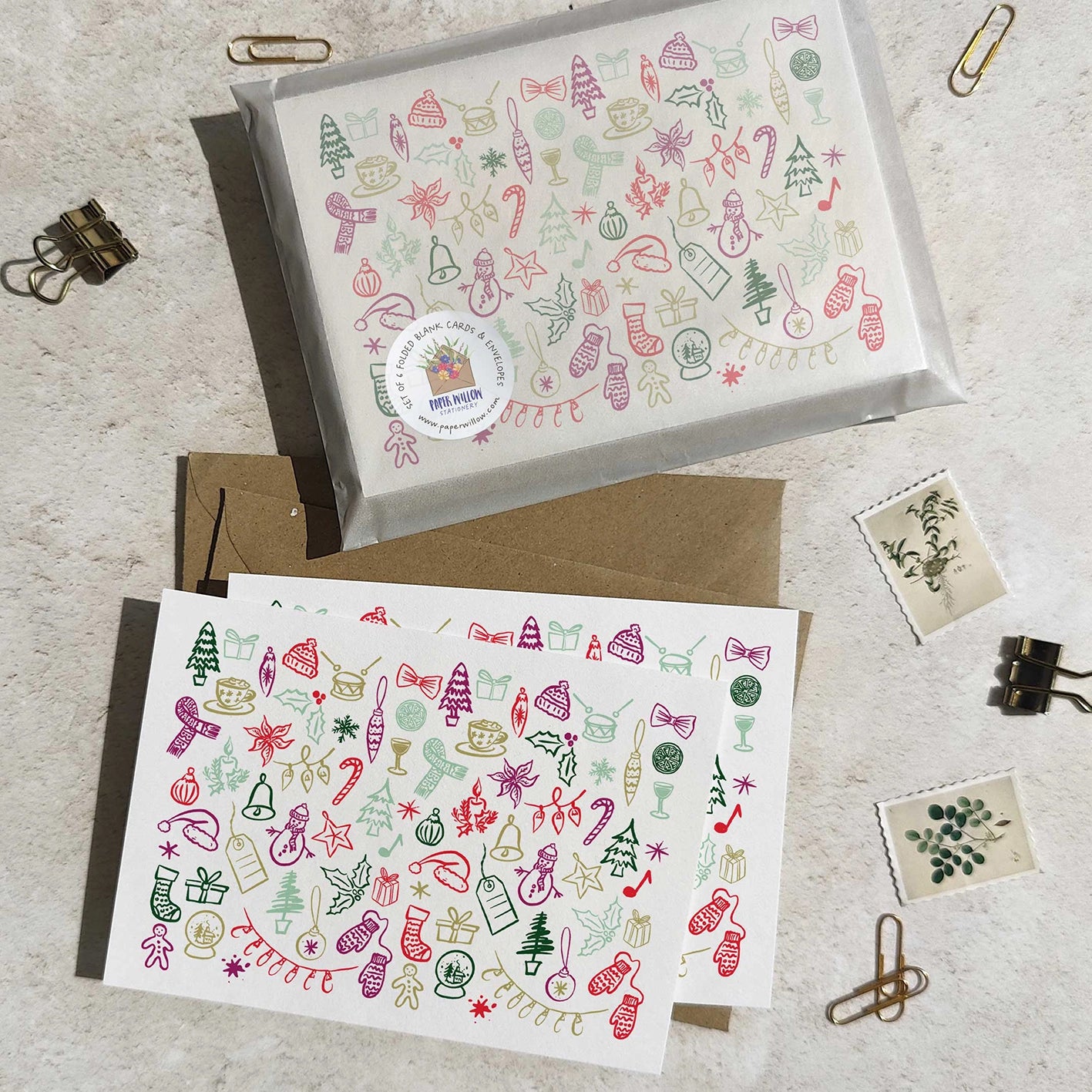 Two Christmas-themed greeting cards with decorative patterns on a light surface.