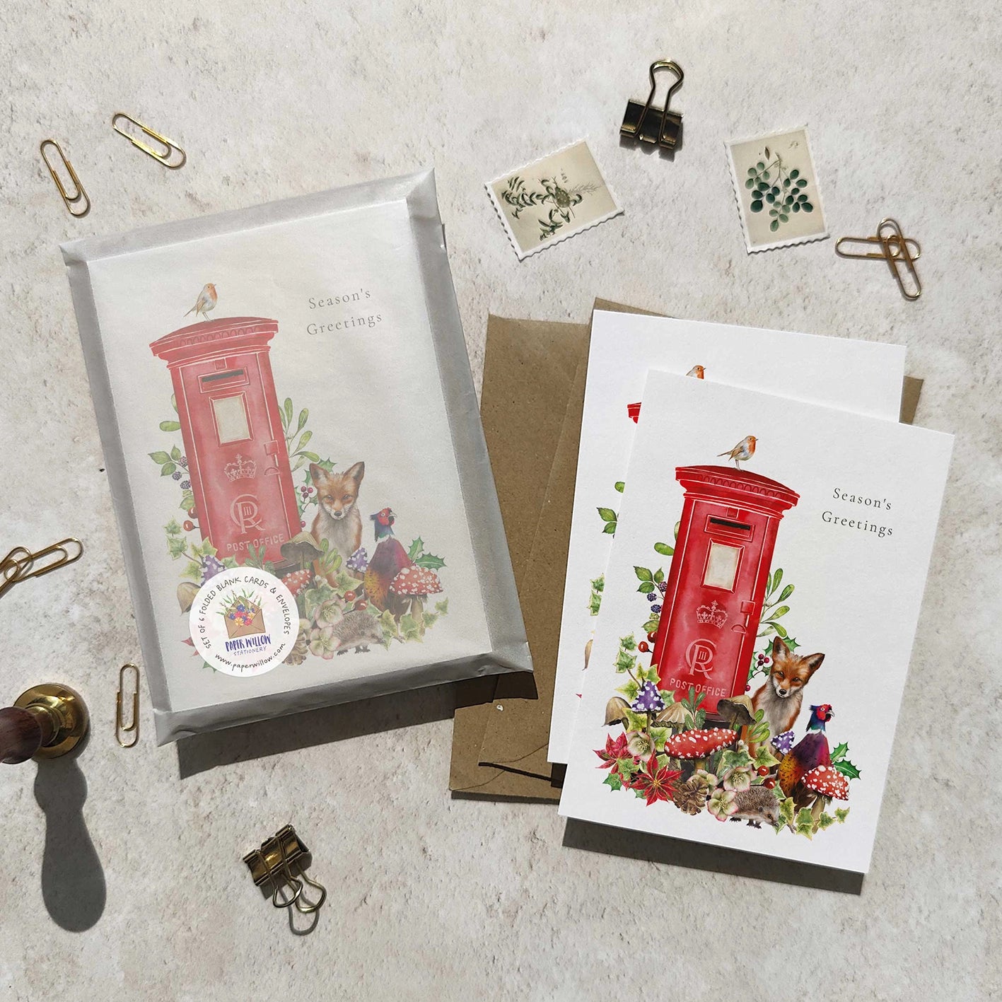 Greeting cards with a red postbox and fox illustration on a textured surface.