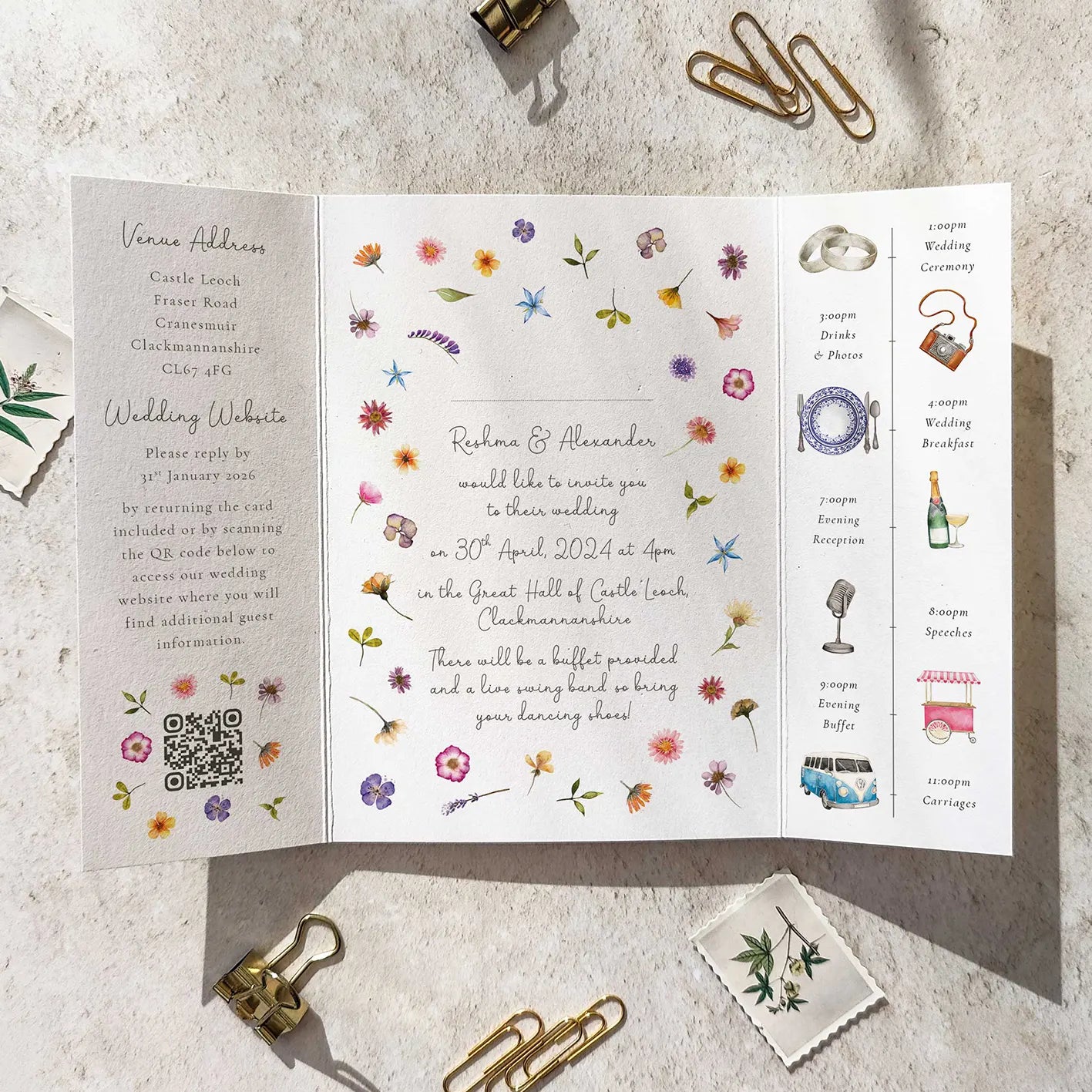 Floral wedding invitation with RSVP details on a textured surface