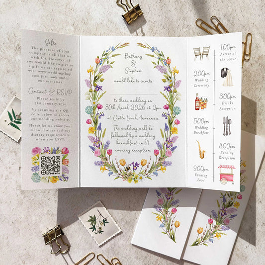 Wedding invitation card with floral design and event schedule on a textured surface.