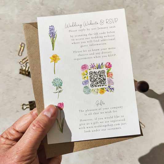 Wedding invitation card with QR code and floral illustrations held by a hand.