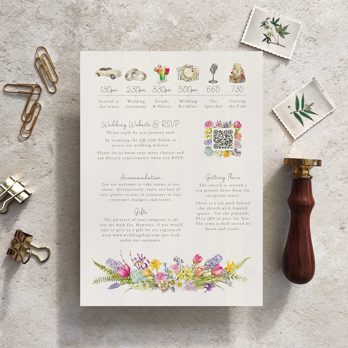 Wedding invitation card with floral design on a textured surface with stationery items.