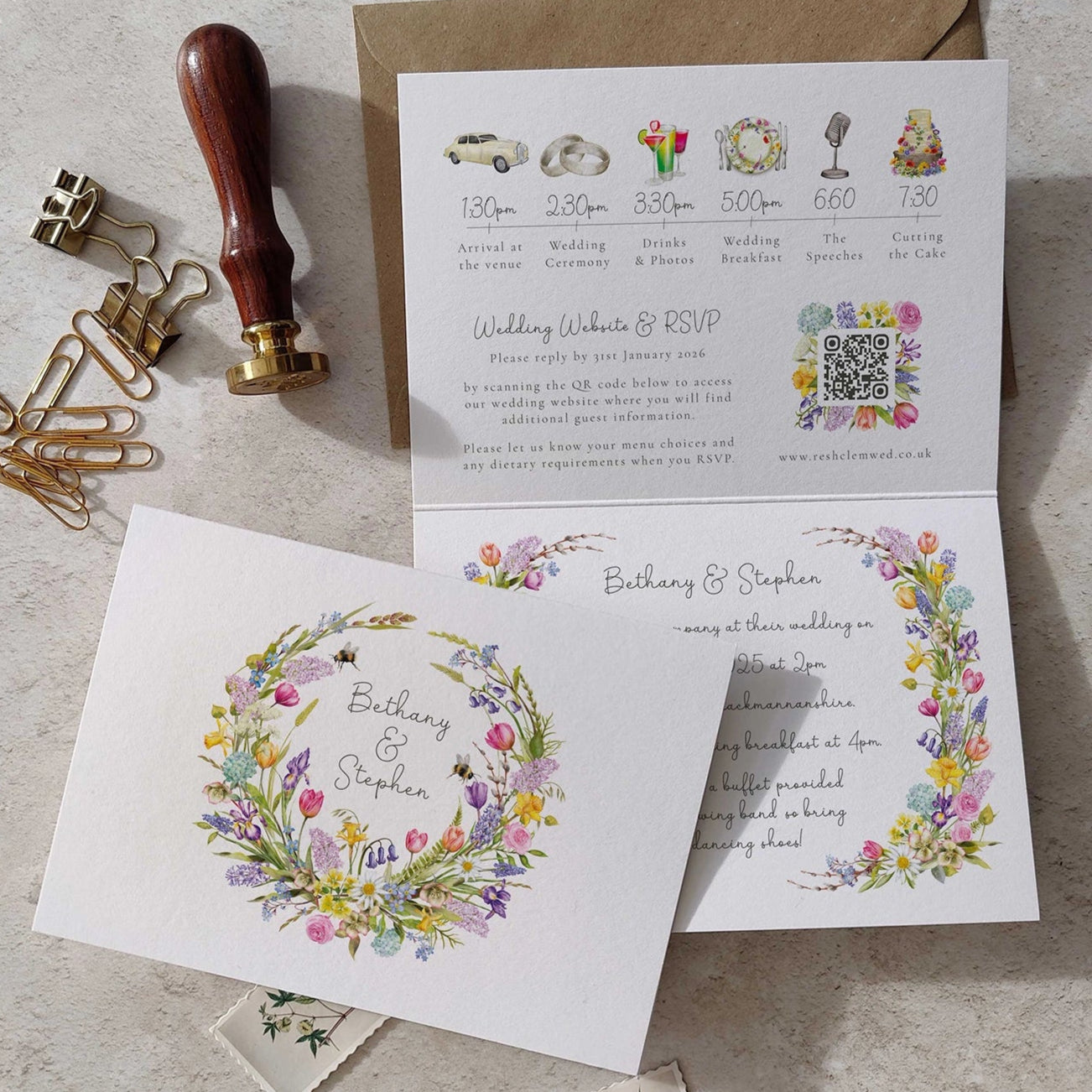 Wedding invitation card with spring floral design and envelope on a textured surface.