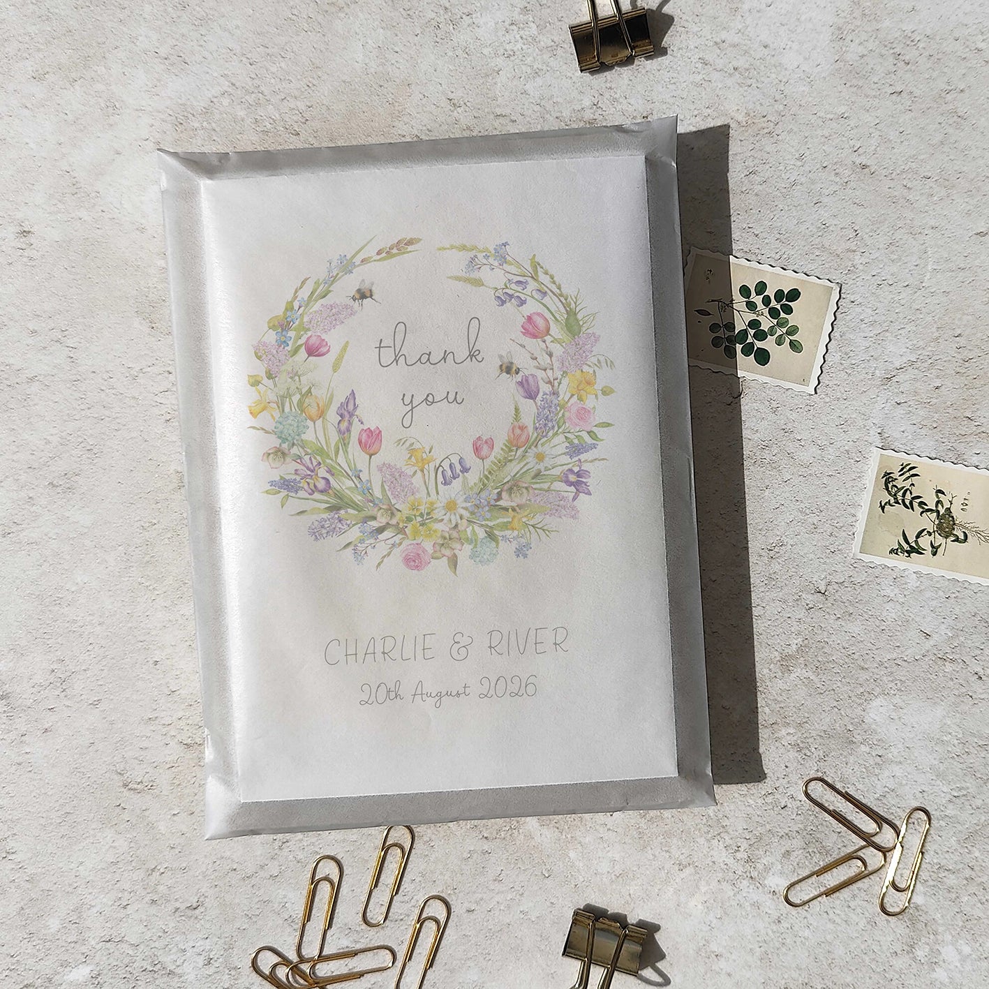 Greeting card with floral design and text on a textured surface with stationery items.