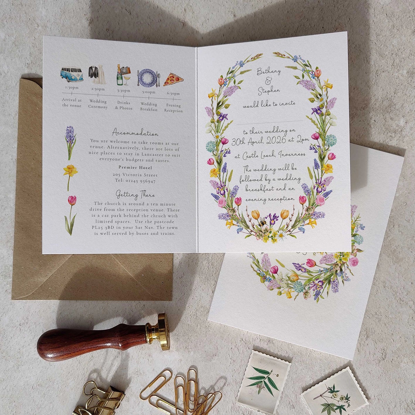 Open wedding invitation card with floral design on a textured surface.