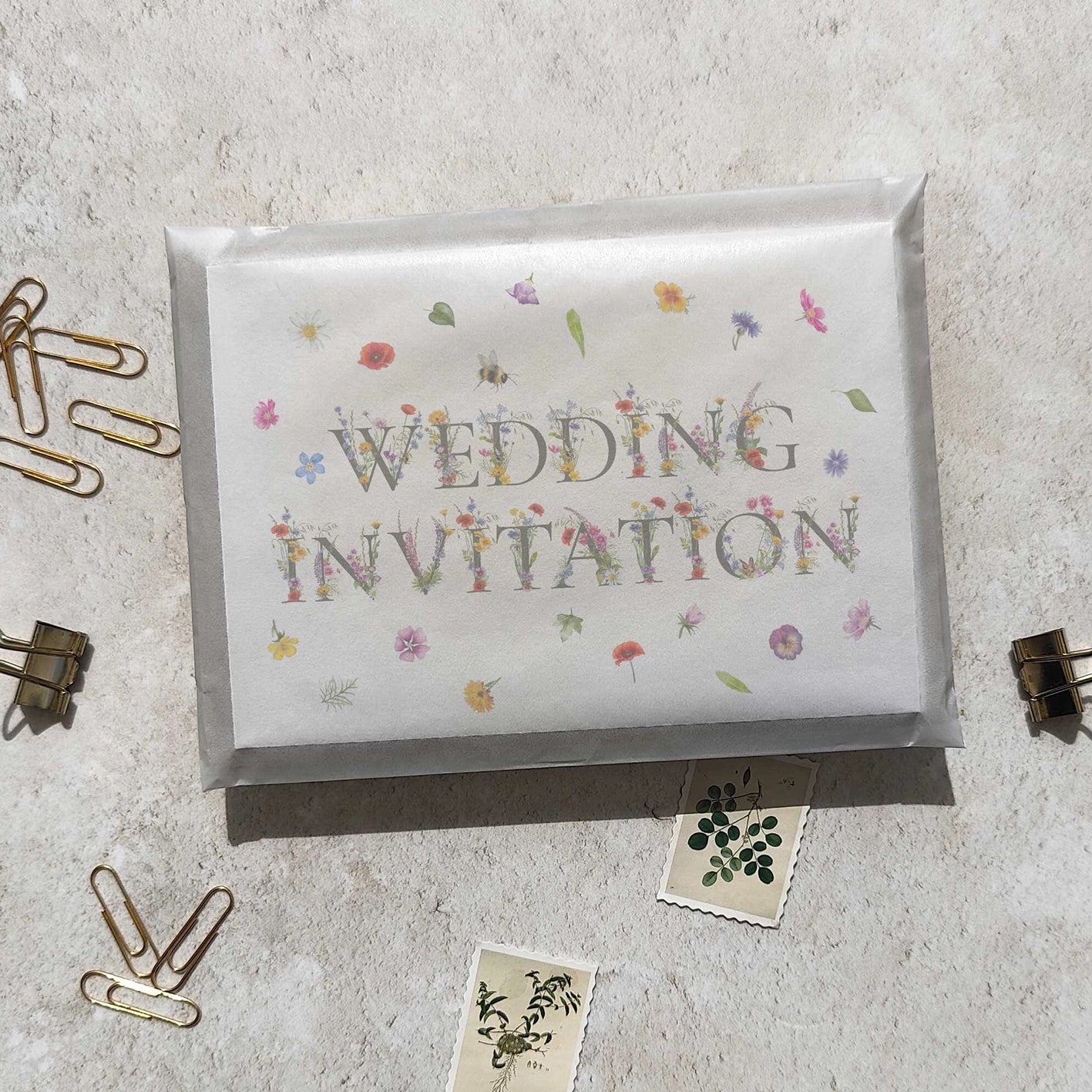 Wedding invitation card with floral decorations on a textured surface.