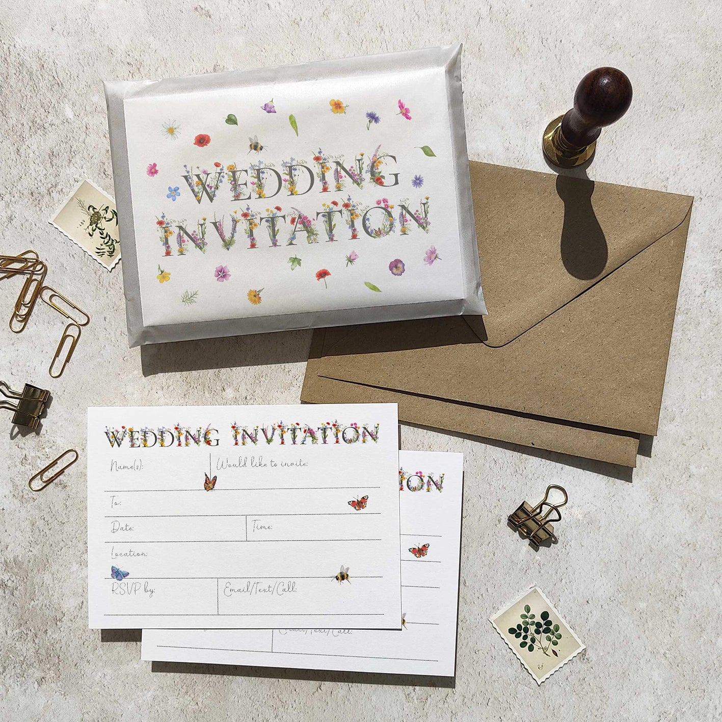 Wedding invitation set with envelope, card, and stationery items on a textured surface