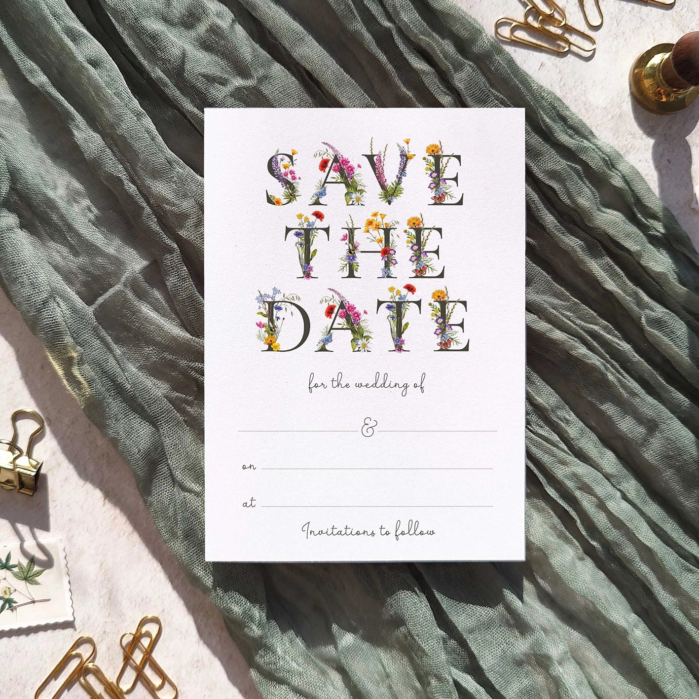 Save the date card with floral text on a textured fabric background