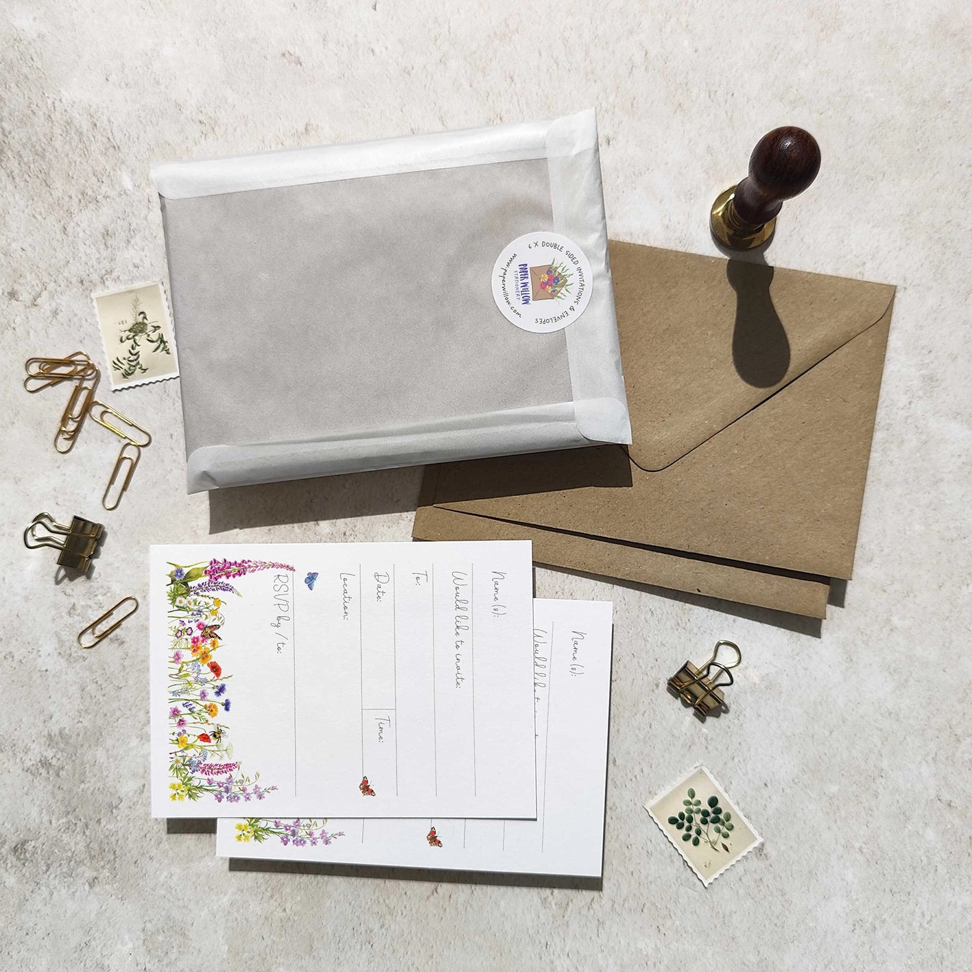 Stationery items including envelopes, postcards, and a stamp on a textured surface