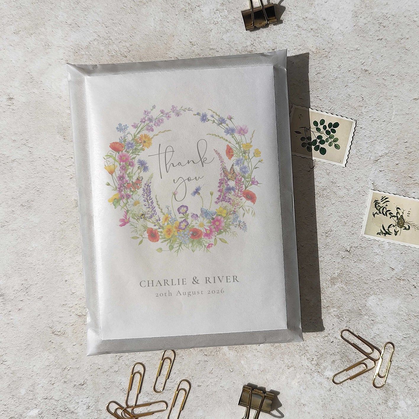 Greeting card with floral design and text on a textured surface with stationery items.