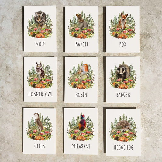Set of nine cards with illustrations of various forest animals on a textured wall background.