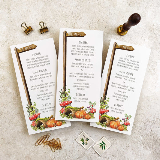 Three menu cards with autumn-themed design on a textured surface.