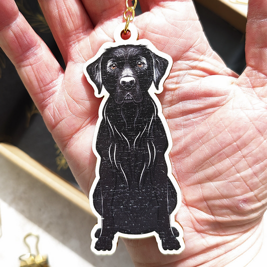 Black labrador dog-shaped keychain held in a hand