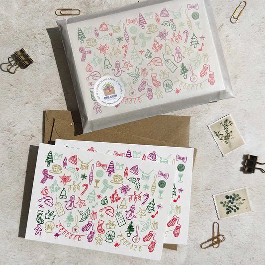 Two Christmas-themed greeting cards with decorative patterns on a light surface.