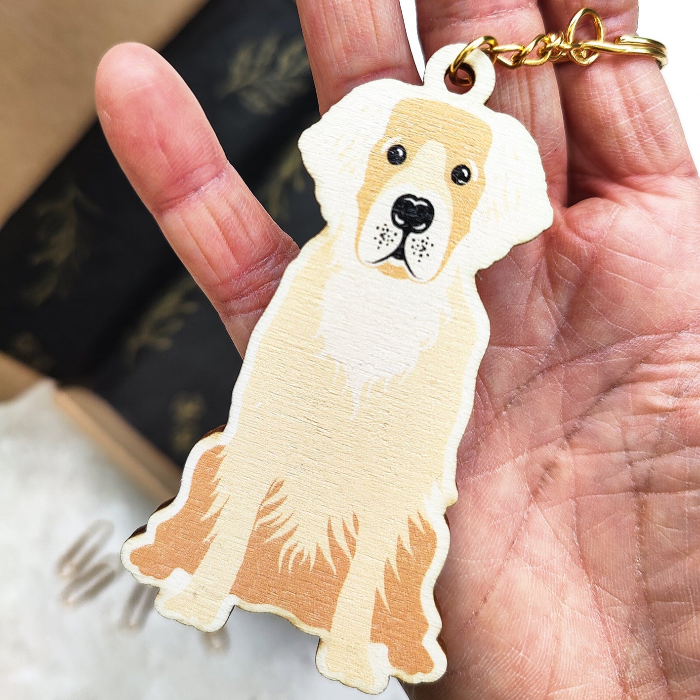 Dog-shaped keychain held in a hand with a blurred background