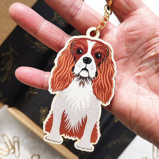 Dog-shaped keychain held in a hand with a blurred background