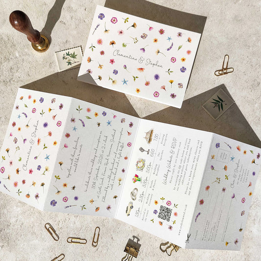 Floral patterned wedding invitation set with envelope on a textured surface