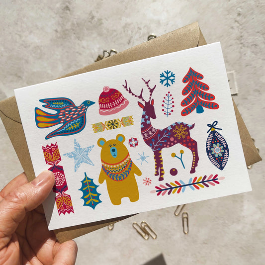 Colorful illustrated card with various patterns held by a hand on a neutral background