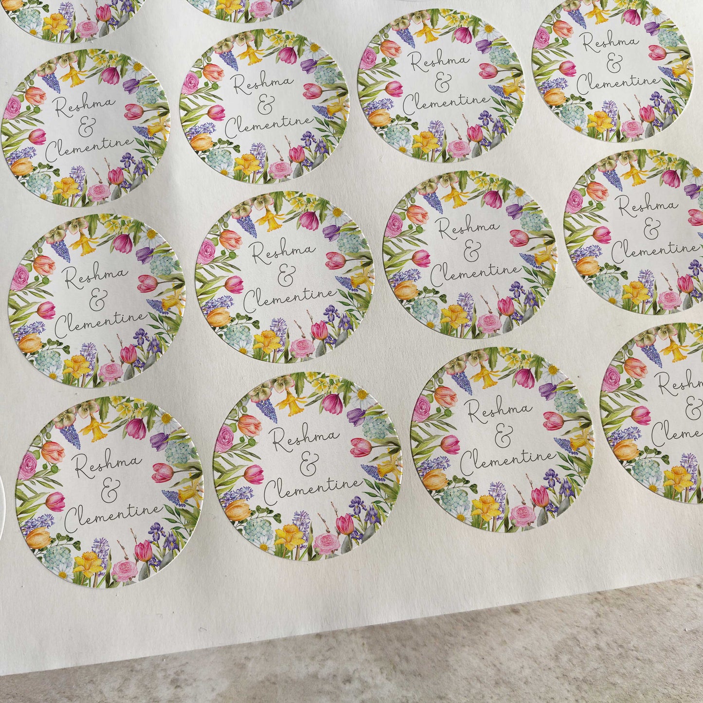 Sheet of round stickers with floral designs and text on a white background