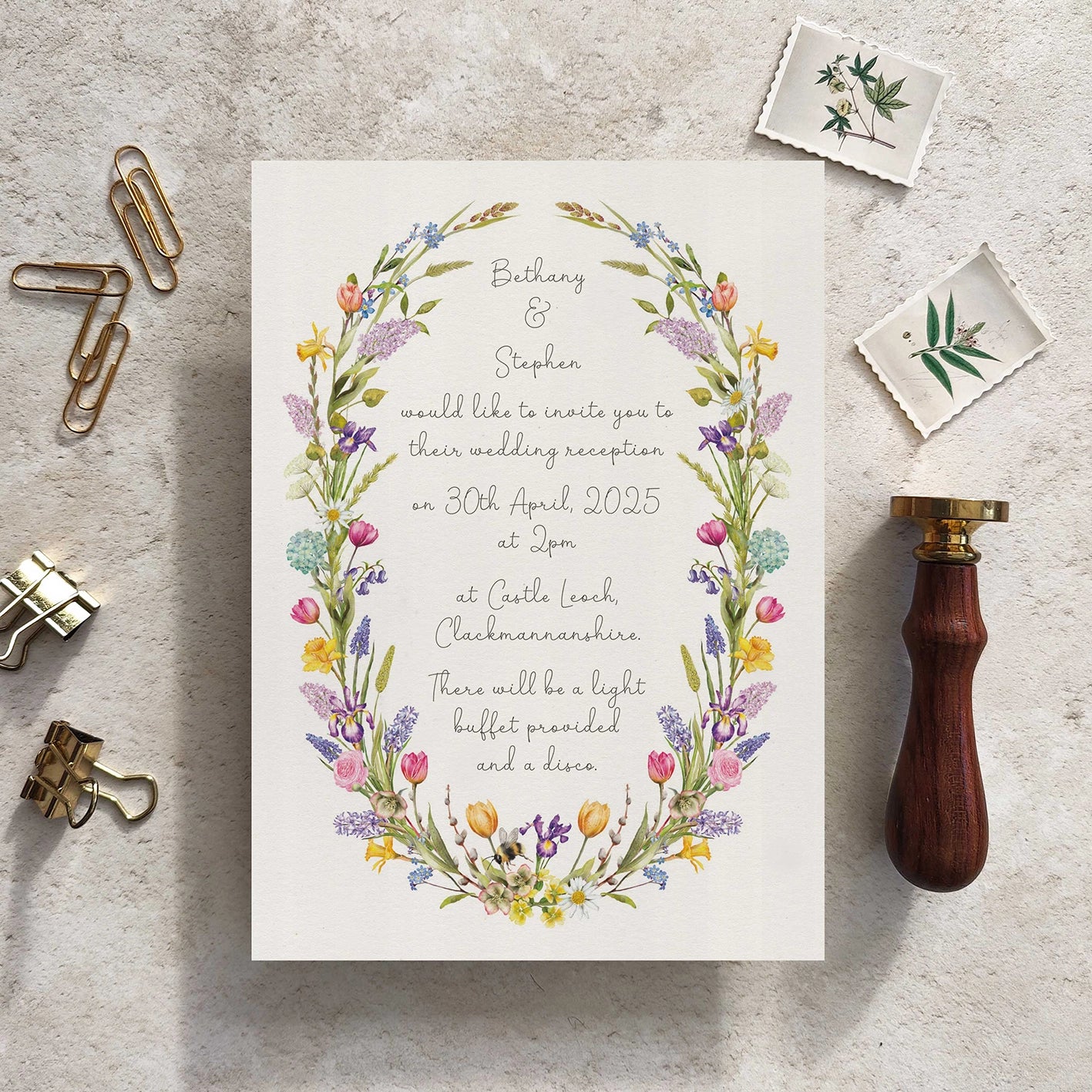 Wedding reception invitation with floral design on a textured surface with stationery items.