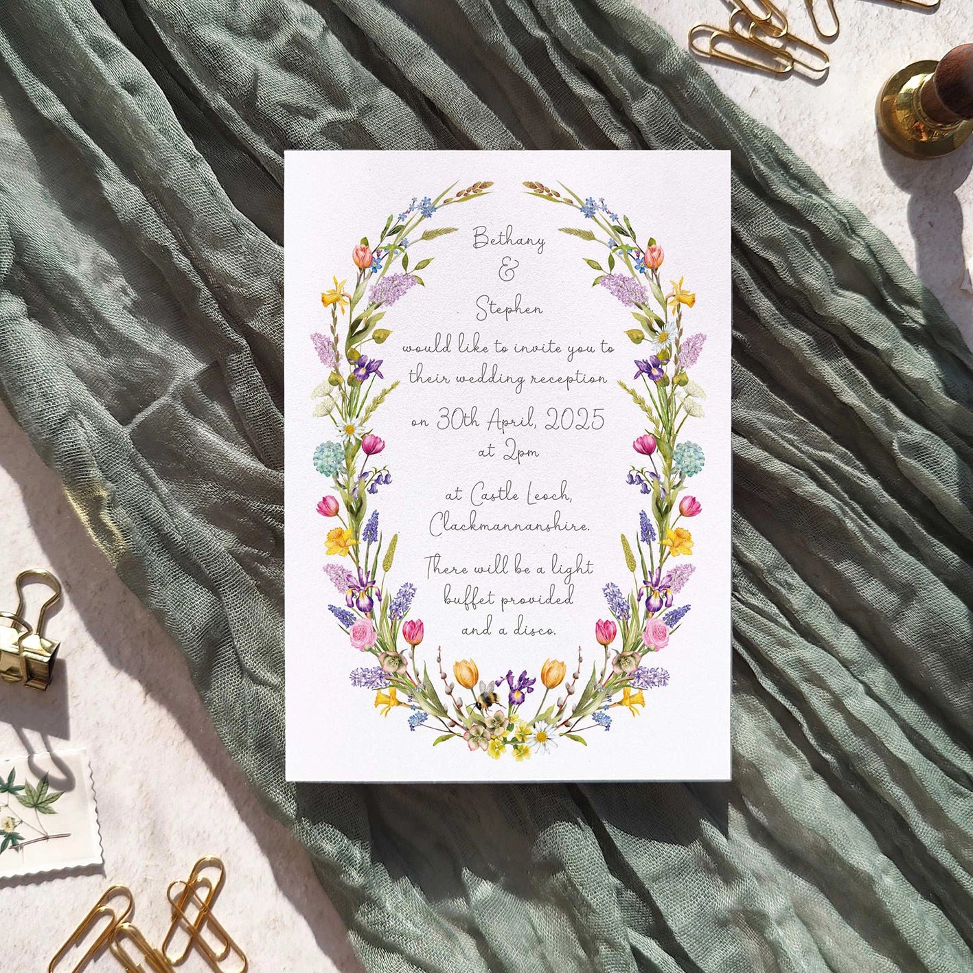 Wedding invitation card with spring floral design on a textured fabric background