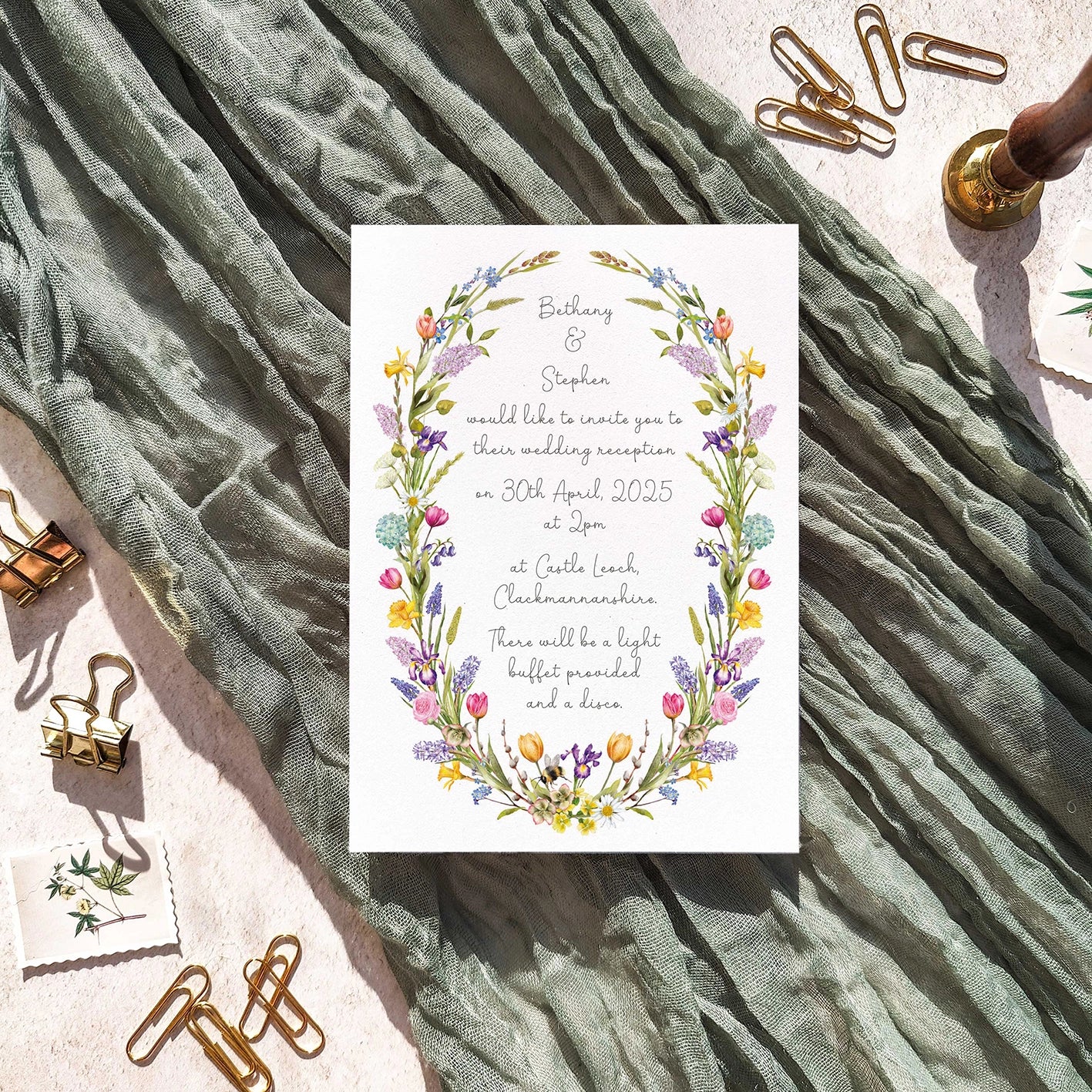 Wedding invitation card with spring floral design on a textured fabric background