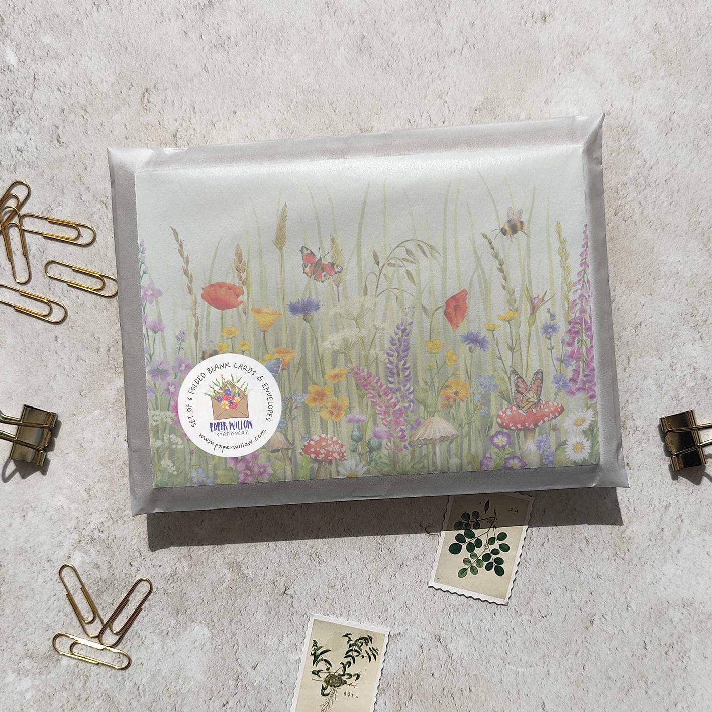 Decorative card with floral design and a visible brand label on a textured surface.