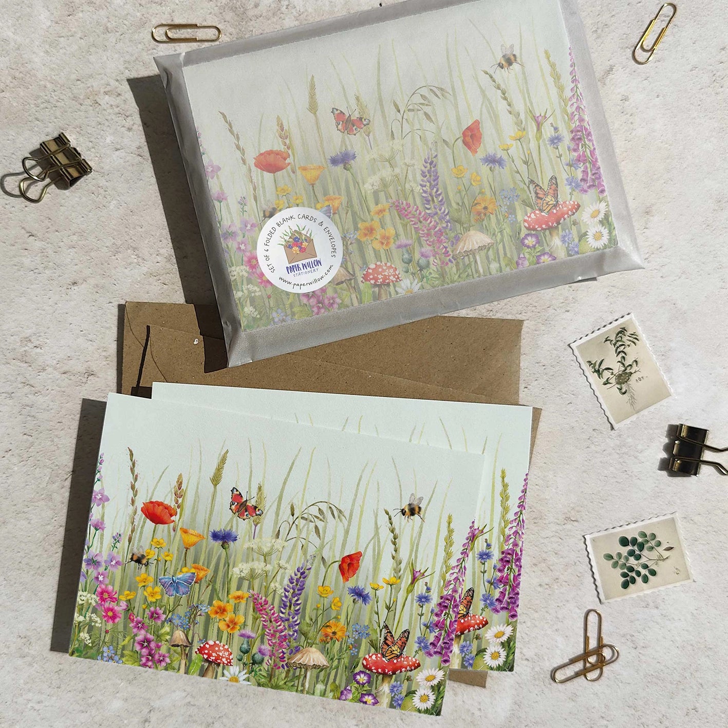 Two greeting cards with floral designs on a textured surface.