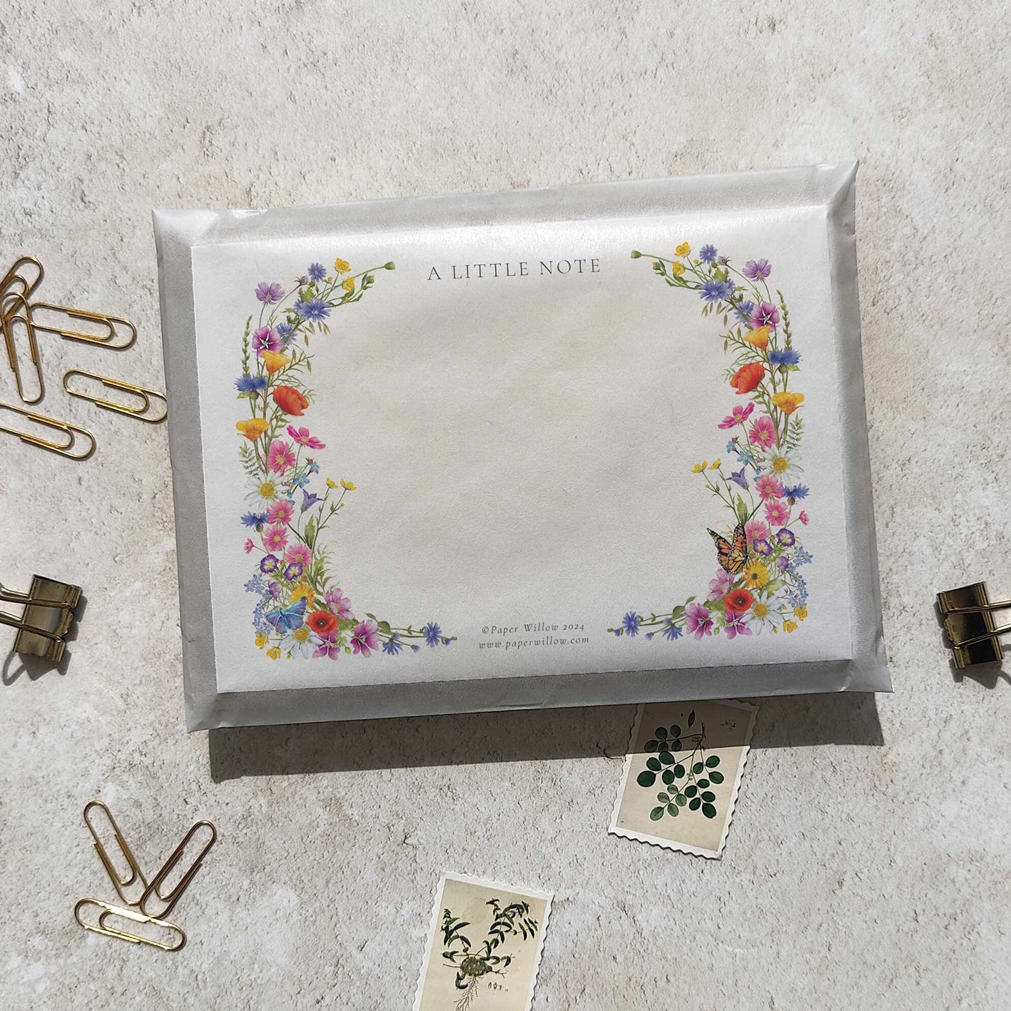 Floral design on a notepad with paper clips and stickers on a light surface